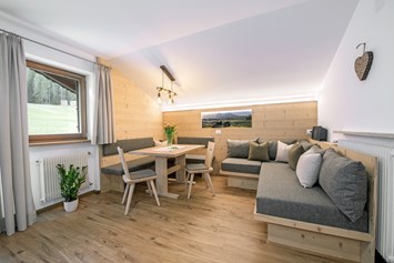 Unterkunft: Wohnraum mit gemütlicher Sitzecke und Schlafcouch aus einheimischen Fichtenholz - Apartment Haus Pötzes